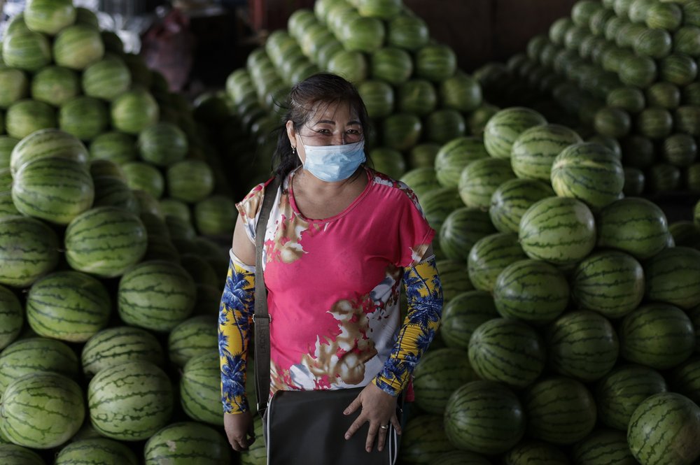 62-year-old fruit vendor Peda Tuazon poses at her stall in Manila, Philippines on Tuesday, July 21, 2020. Tuazon said she will convince the person to wear a mask to prevent the spread of COVID.