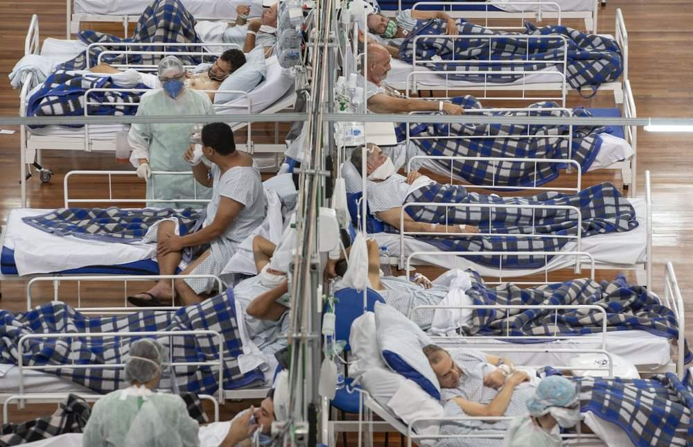 FILE - In this June 9, 2020, file photo COVID-19 patients lie on beds in a field hospital built inside a gym in Santo Andre, on the outskirts of Sao Paulo, Brazil. A new snapshot of the frantic global response to the coronavirus pandemic shows some of the world's largest government donors of humanitarian assistance are buckling under the strain and overall aid commitments have dropped by a third from the same period last year. 