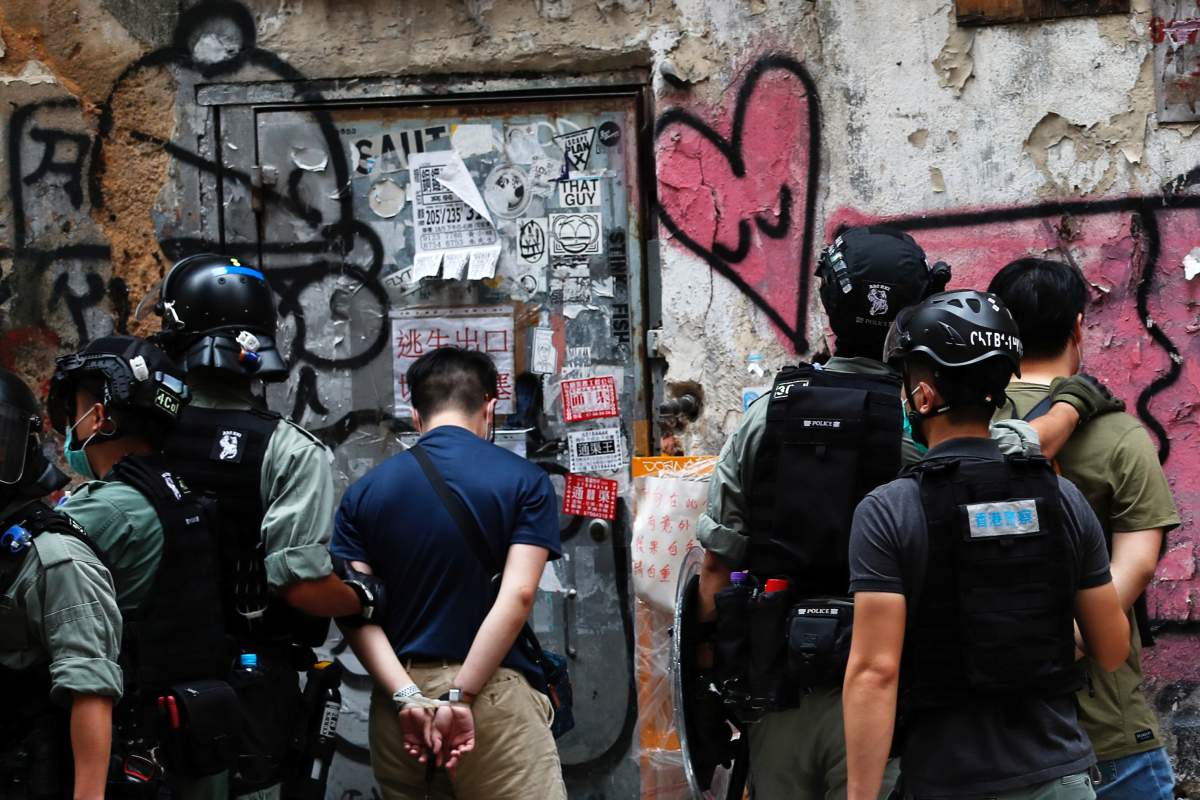 Men are detained by riot police during a march against national security law at the anniversary of Hong Kong’s handover to China from Britain in Hong Kong, China July 1, 2020. REUTERS/Tyrone Siu