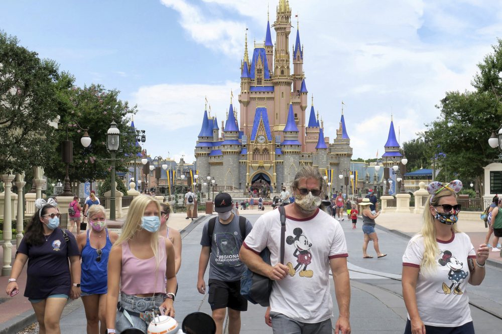 Guests wear masks as required to attend the official reopening day of the Magic Kingdom at Walt Disney World in Lake Buena Vista, Fla., Saturday, July 11, 2020.