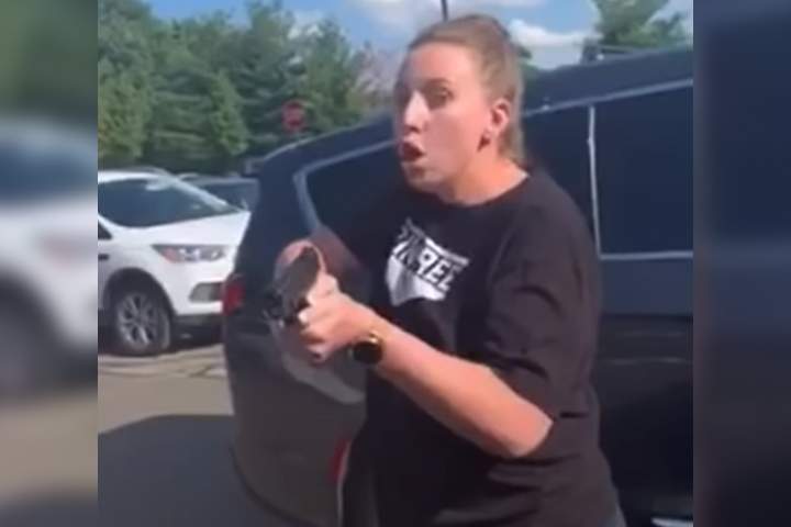 A woman is shown with what appears to be a pistol in her hands, in this image captured from video of an encounter in Orion Township, Mich., on July 1, 2020.