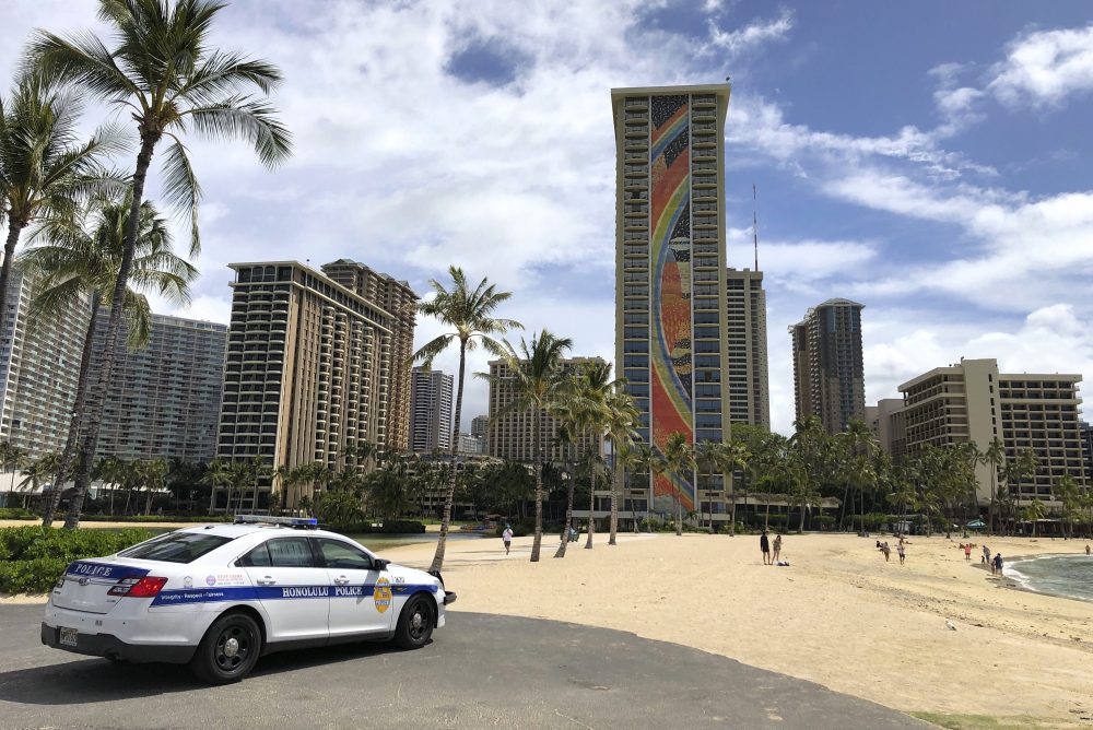 In this March 28, 2020 file photo a police officer arrives at Waikiki Beach in Honolulu.