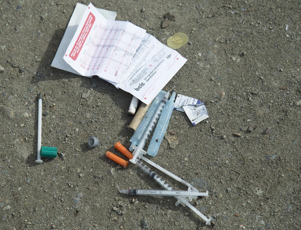 Needles are seen on the ground in Oppenheimer park in Vancouver's downtown eastside on March 17, 2020. Indigenous and civil liberties groups say the British Columbia government failed to consult them before proposing legislation that would force youth under 19 to stay in hospital after an overdose. THE CANADIAN PRESS/Jonathan Hayward.