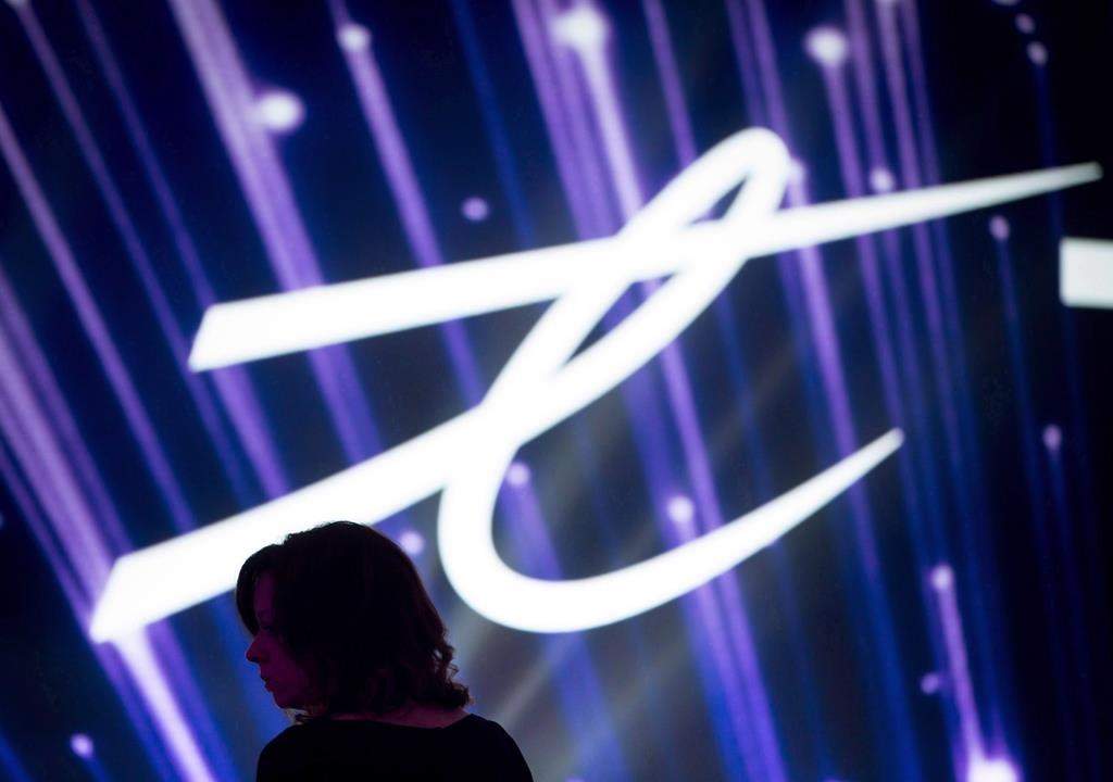 A woman is silhouetted as the Telus Corp. logo is displayed on a screen during a company event in Vancouver on Friday, October 2, 2015. THE CANADIAN PRESS/Darryl Dyck.