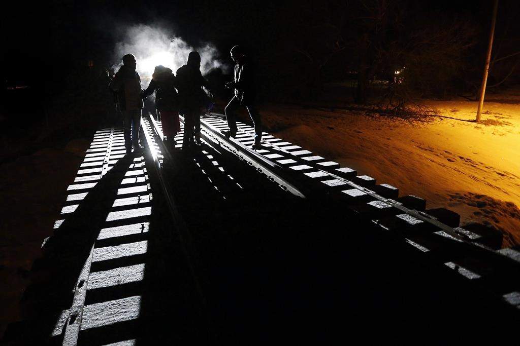 Migrants from Somalia cross into Canada illegally from the United States by walking down a train track into the town of Emerson, Man., on Feb. 26, 2017.