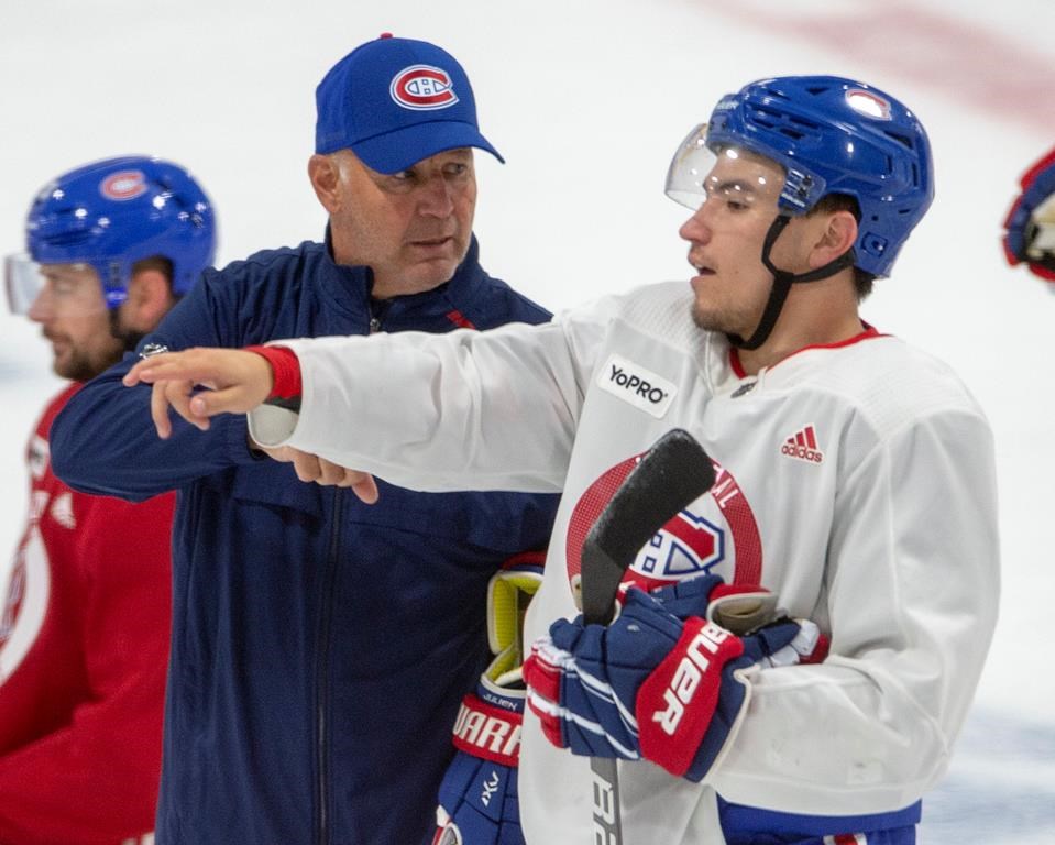 Montreal Canadiens head coach Claude Julien, goes over a drill with forward Nick Suzuki during practice Friday, July 17, 2020 in Brossard, Que.