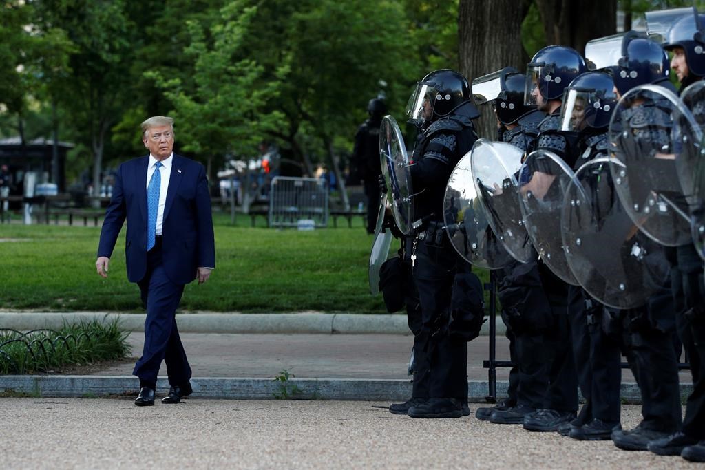 FILE – In this June 1, 2020, file photo President Donald Trump walks past police in Lafayette Park after visiting outside St. John\’s Church across from the White House in Washington. When it comes to squelching protests in Democrat-run cities, Trump is eager to send in federal troops and agents — even when local leaders are begging him to butt out.