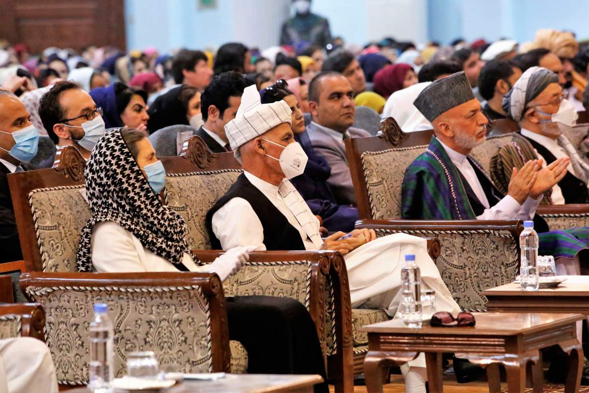 Afghan President Ashraf Ghani, center left, wears a protective face mask to help curb the spread of the coronavirus, on the last day of an Afghan Loya Jirga or traditional council, in Kabul, Afghanistan, Aug. 9, 2020.