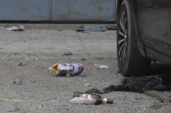 Discarded shoes and beer bottles litter the area outside the Tomas Restobar disco where officials say 13 people died in a stampede after a police raid to enforce the country's lockdown during the coronavirus pandemic, Sunday, Aug. 23, 2020. The stampede happened when about 120 people that had gathered for a party on Saturday night, tried to escape through the only door of the second-floor disco, trampling one another and becoming trapped in the confined space, according to authorities. 