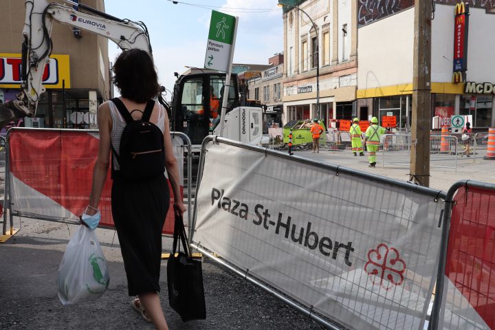 Plaza Saint-Hubert pedestrian walks on temporary pathway while construction continues on St-Hubert Street on Tuesday, Aug. 11, 2020. 