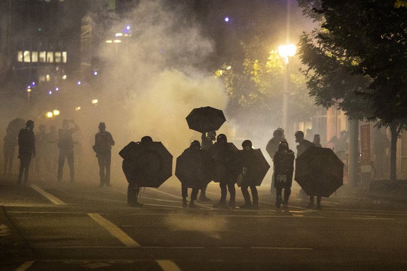 Tear gas fills the air during protests, Friday, Sept. 18, 2020, in Portland, Ore.