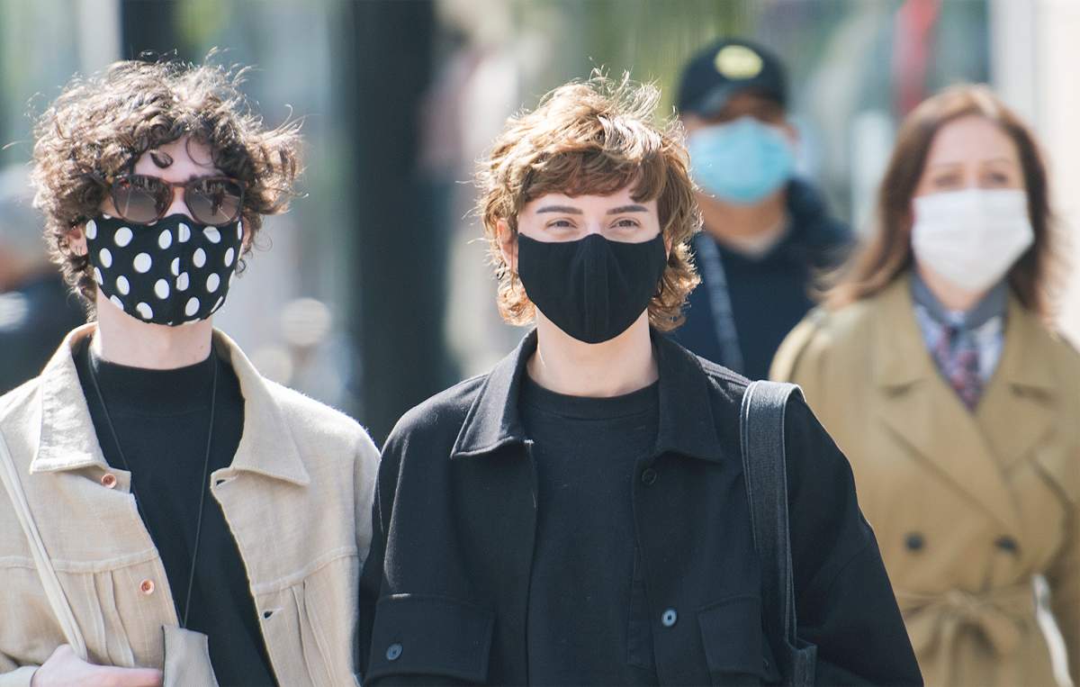 People wear face masks as they wait to cross a street in Montreal, Monday, September 21, 2020, as the COVID-19 pandemic continues in Canada and around the world.