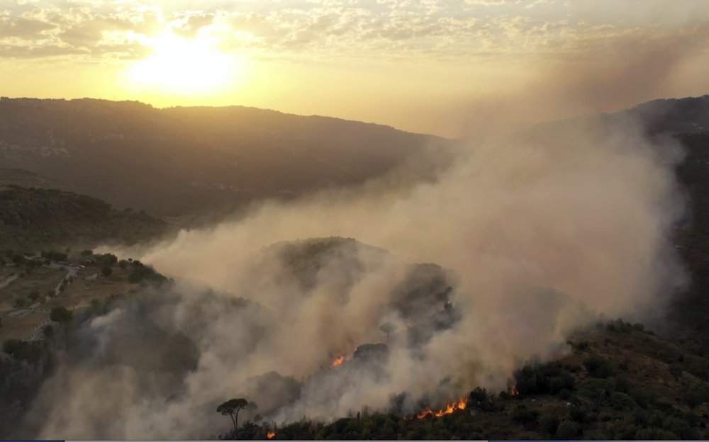 In this frame grab from video, flames rise at the scene of forest fire in Ras el-Harf village, in the Baabda district, Lebanon, Friday, Oct. 9, 2020. Wildfires around the Middle East triggered by a heatwave hitting the region have killed two people, forced thousands of people to leave their homes and detonated landmines along the Lebanon-Israel border, state media and officials said Saturday.