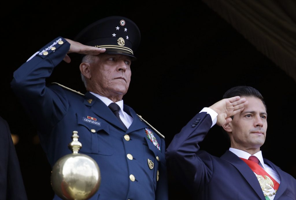 FILE - In this Sept. 16, 2016 file photo, Defense Secretary Gen. Salvador Cienfuegos, left, and Mexico's President Enrique Pena Nieto, salute during the annual Independence Day military parade in Mexico City's main square. Mexico's top diplomat says the country's former defense secretary, Gen. Salvador Cienfuegos, has been arrested in Los Angeles. Foreign Relations Secretary Marcelo Ebrard wrote Thursday, Oct. 15, 2020 in his Twitter account that U.S. Ambassador Christopher Landau had informed him of Cienfuegos' arrest. 