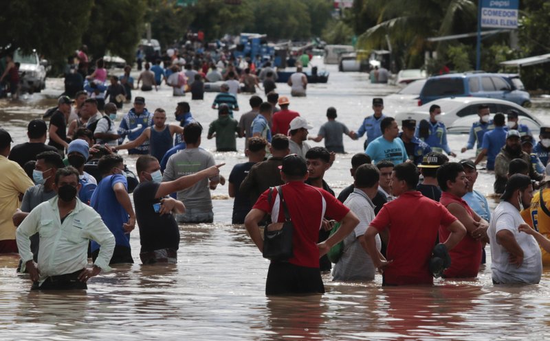 Residents wade through a flooded road in the aftermath of Hurricane Eta in Planeta, Honduras, Thursday, Nov. 5, 2020. The storm that hit Nicaragua as a Category 4 hurricane on Tuesday had become more of a vast tropical rainstorm, but it was advancing so slowly and dumping so much rain that much of Central America remained on high alert.
