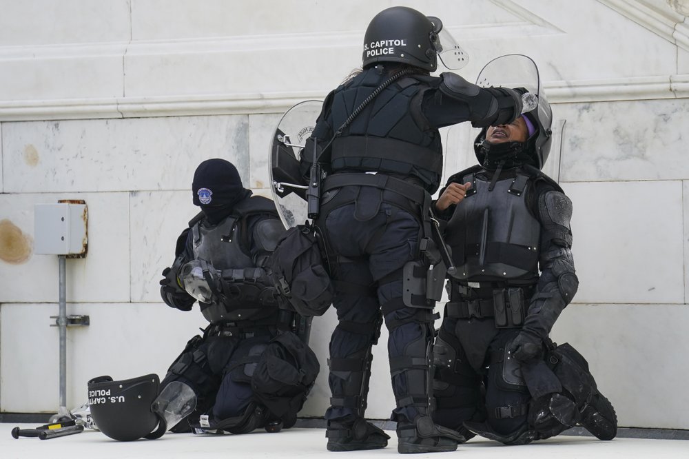 A police officer has eyes flushed with water after a confrontation with demonstrators, Wednesday, Jan. 6, 2021, at the Capitol in Washington.