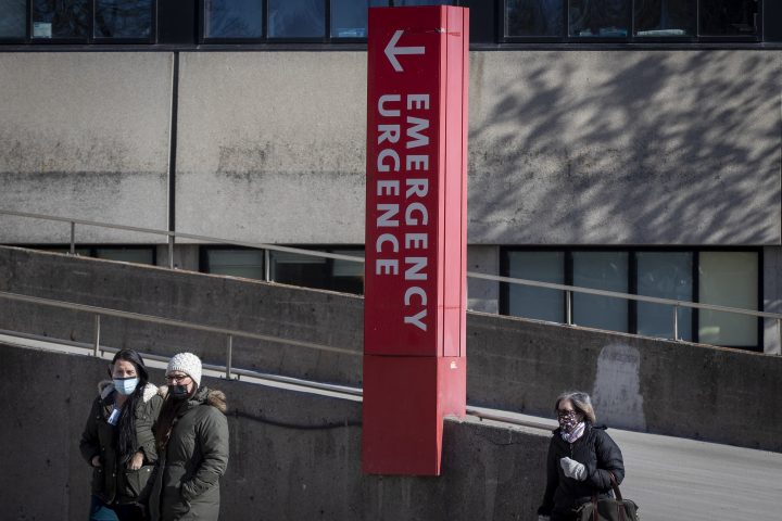 People wear masks to protect them from the COVID-19 virus as they walk past the emergency at Kingston General Hospital (KGH) in Kingston, Ontario on Thursday, February 4, 2021.