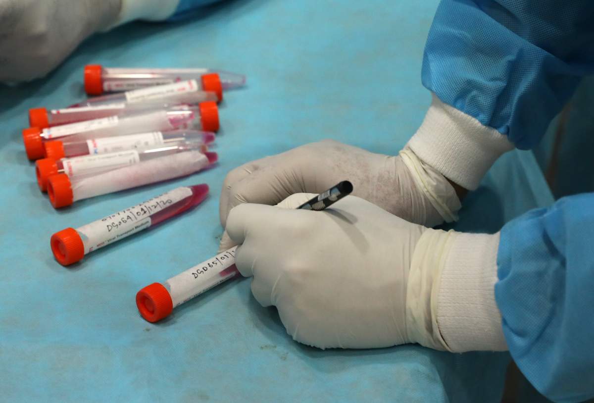 A health worker prepares vials to collect swab samples for a COVID-19 RT-PCR test. 