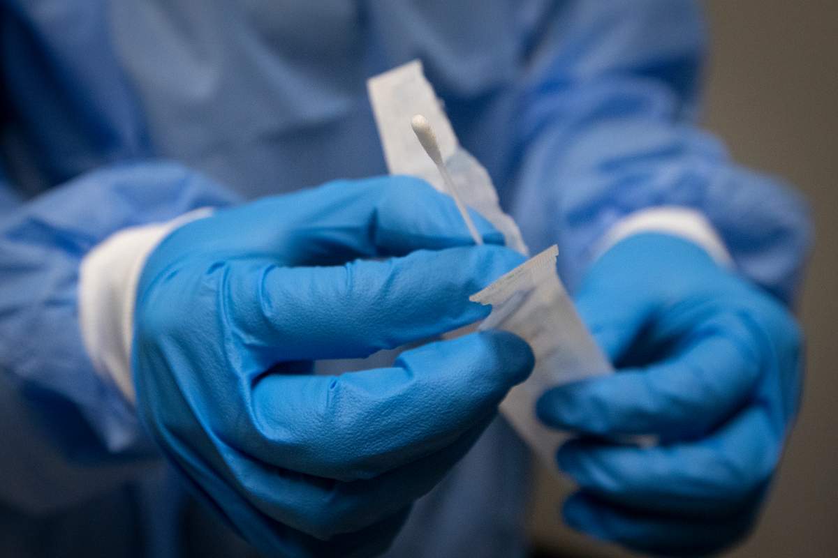 A pharmacist holds a COVID-19 test swab at a pharmacy in Amherstview, Ontario on Friday, January 22, 2021, as the COVID-19 pandemic continues across Canada and around the world. THE CANADIAN PRESS IMAGES/Lars Hagberg.