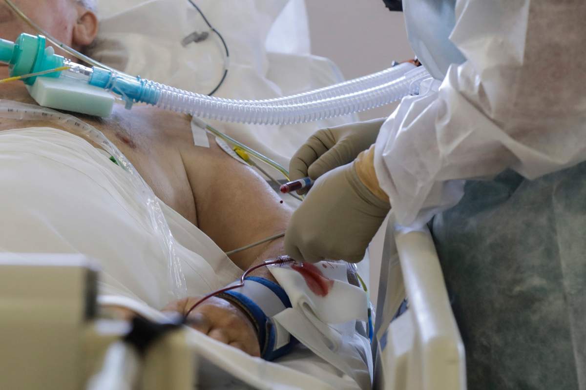 FILE - In this Friday, Nov. 6, 2020 file photo, Doctor Davide Maraggia tends to a patient, in the Intensive Care Unit of the Varese’s Circolo Hospital, in Varese, Italy. (AP Photo/Luca Bruno).
