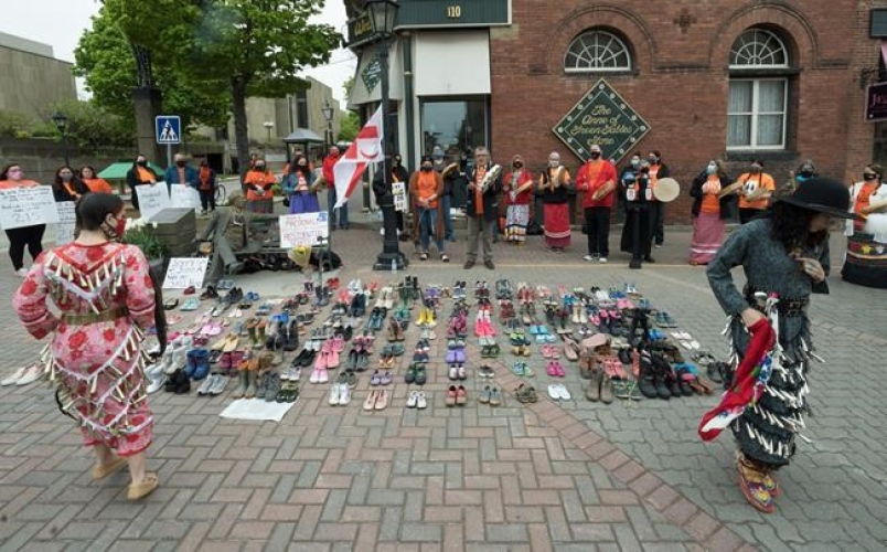 Two Indigenous dancers perform around the 215 pairs of children's shoes placed next to a Sir John A. Macdonald statue in Charlottetown on Monday, May 31, 2021, during a ceremony for the remains of 215 children found at the Kamloops Indian Residential School.