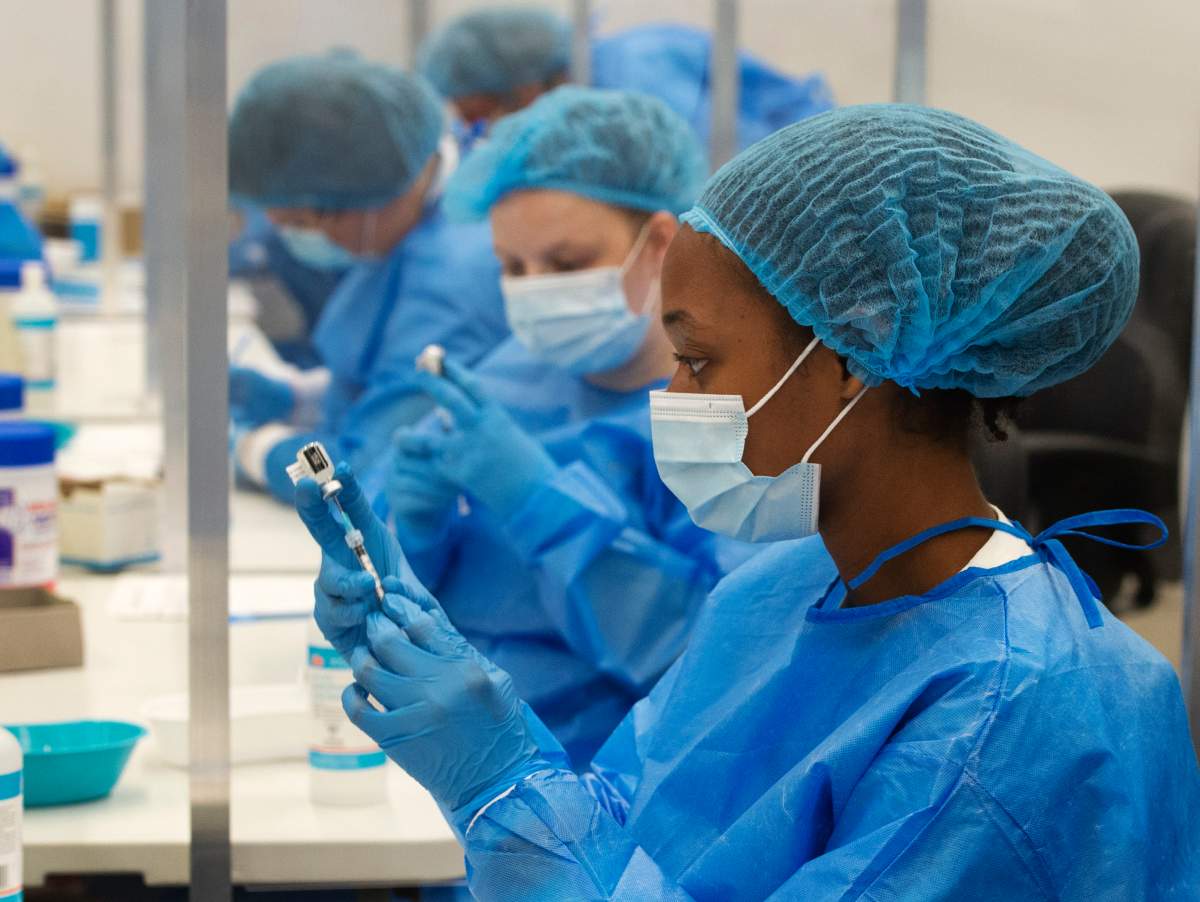 Healthcare workers prepare doses of the Pfizer vaccine at a COVID-19 vaccination clinic, Thursday, May 13, 2021  in Montreal.