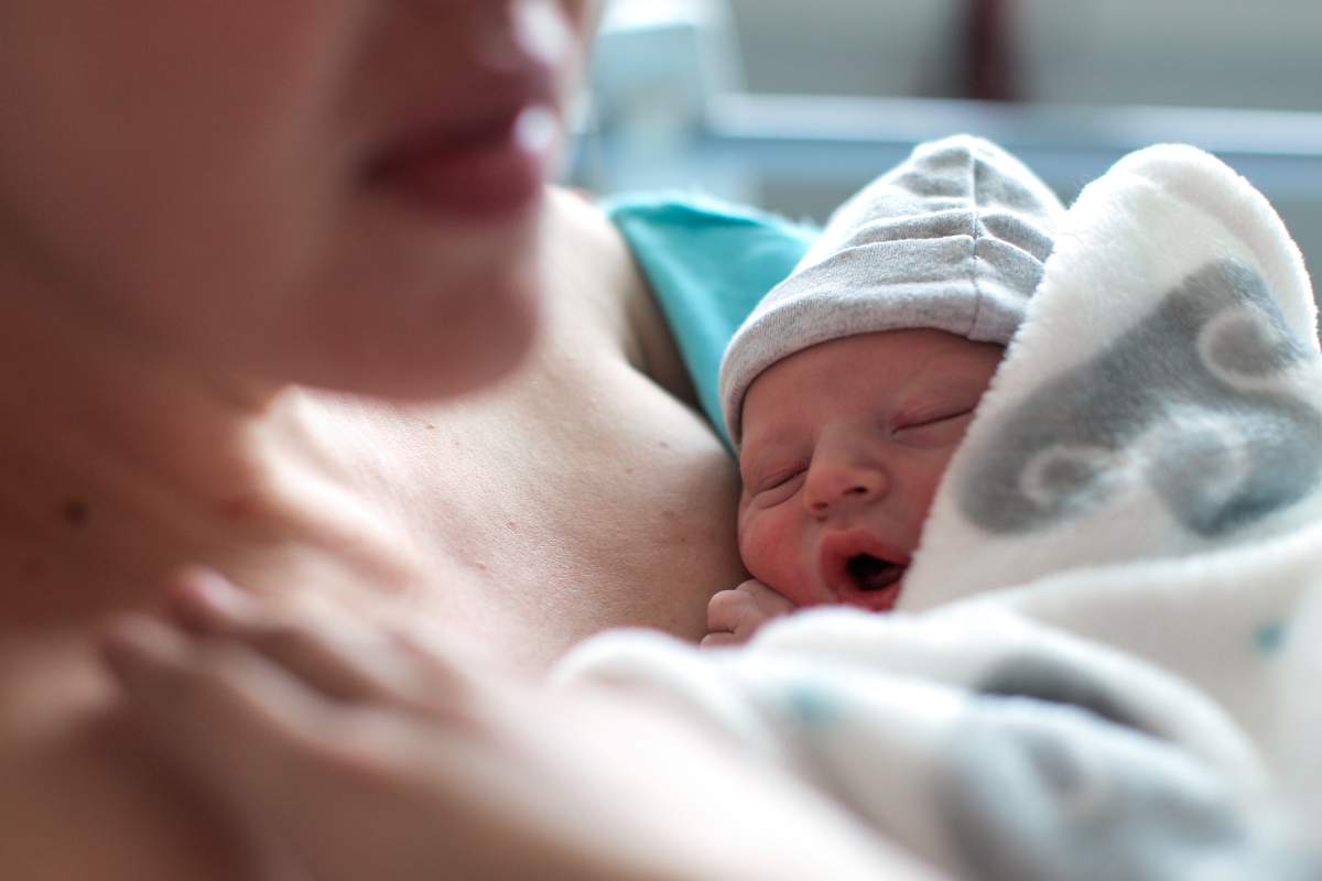 FILE. Newborn baby boy breastfeeding for the first time in hospital, directly after a caesarean section.