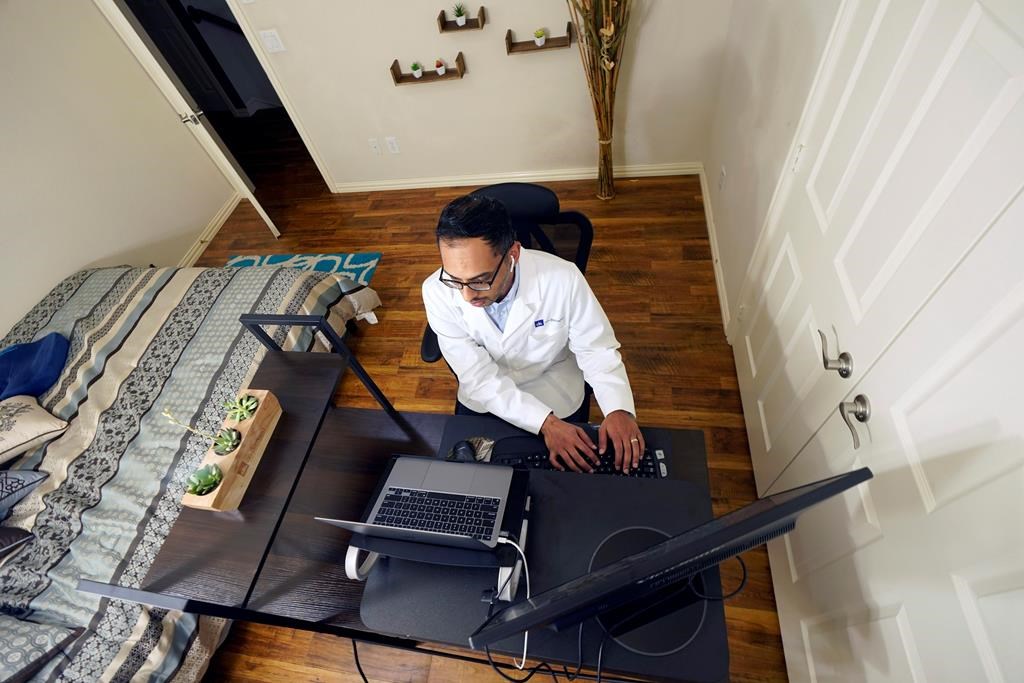 Medical director of Doctor on Demand Dr. Vibin Roy types notes as he listens to a patient during an online primary care visit from his home.