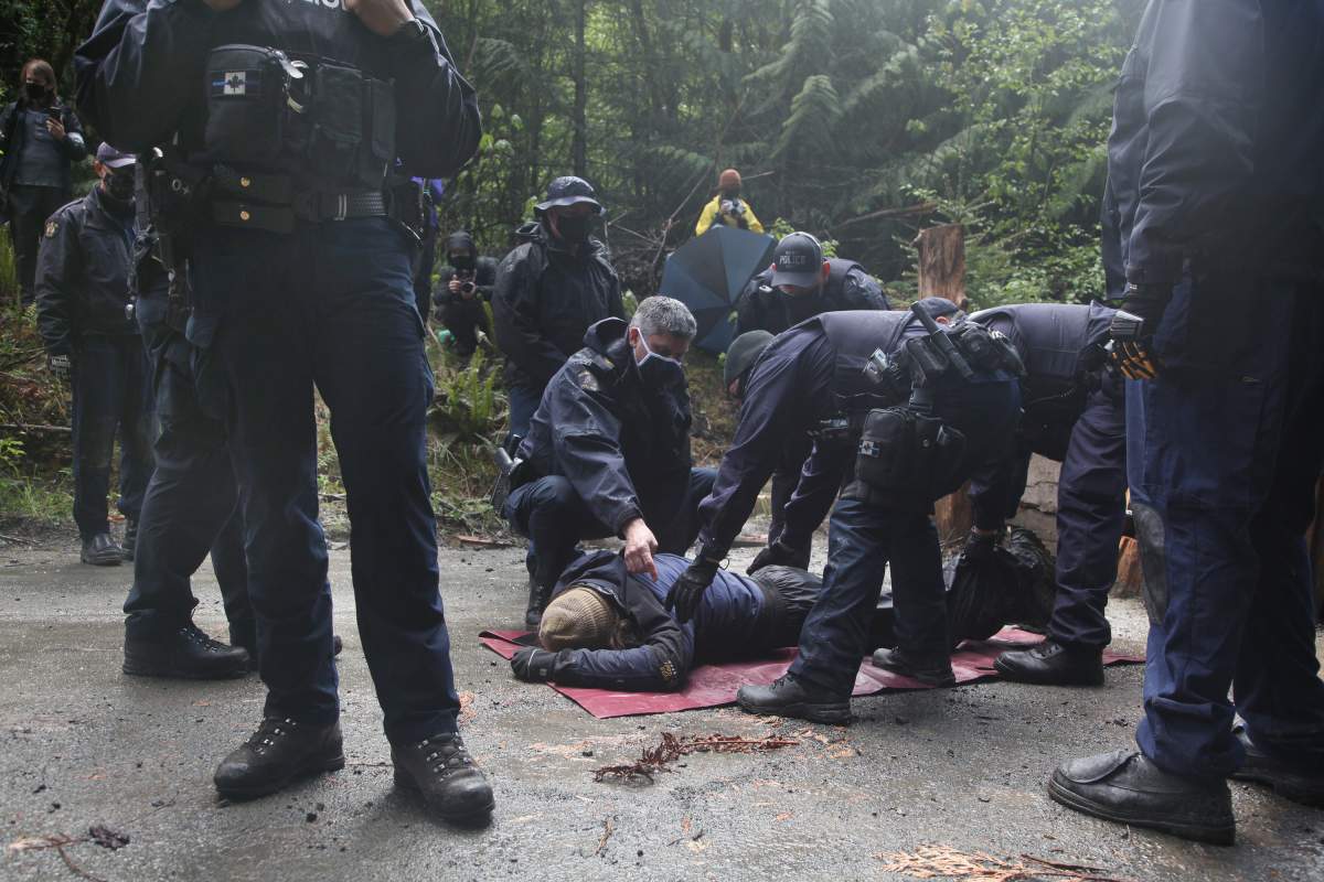 RCMP officers arrest a man during an anti-logging protest in Caycuse, B.C. on Tuesday, May 18, 2021.