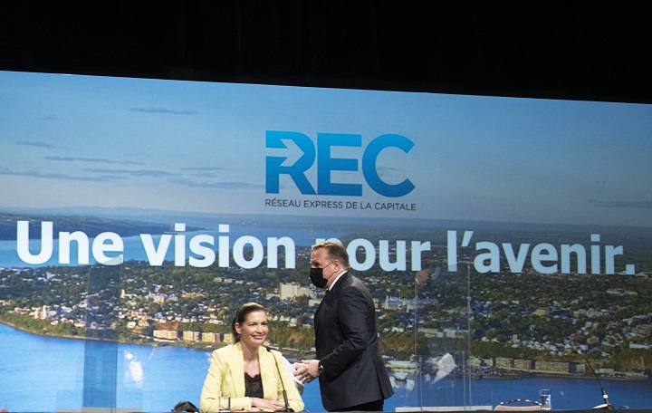 Quebec Premier François Legault walks to the podium to announce the new public transportation network, including a tramway and a tunnel to connect Lévis to Quebec City, Monday, May 17, 2021 in Quebec City. Quebec Deputy premier and Public Security Minister Geneviève Guilbault, sitting, is all smiles. 