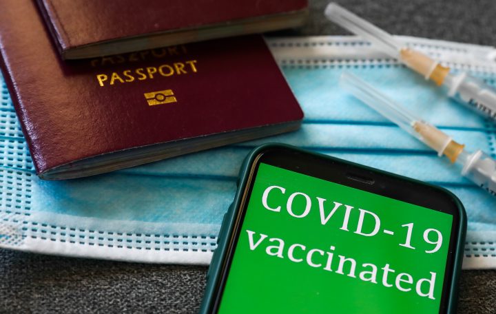 ‘COVID-19 vaccinated’ sign displayed on a phone screen, passports, medical syringes and a face mask are seen in this illustration photo taken in Krakow, Poland on April 28, 2021.