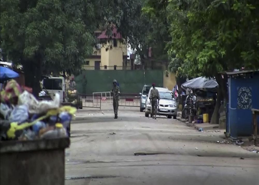 In this image made from video, unidentified soldiers are seen near the presidential palace in the capital Conakry, Guinea Sunday, Sept. 5, 2021. Mutinous soldiers detained President Alpha Conde on Sunday after hours of heavy gunfire rang out near the presidential palace, then announced on state television that the government had been dissolved in an apparent coup d’etat. (AP Photo)