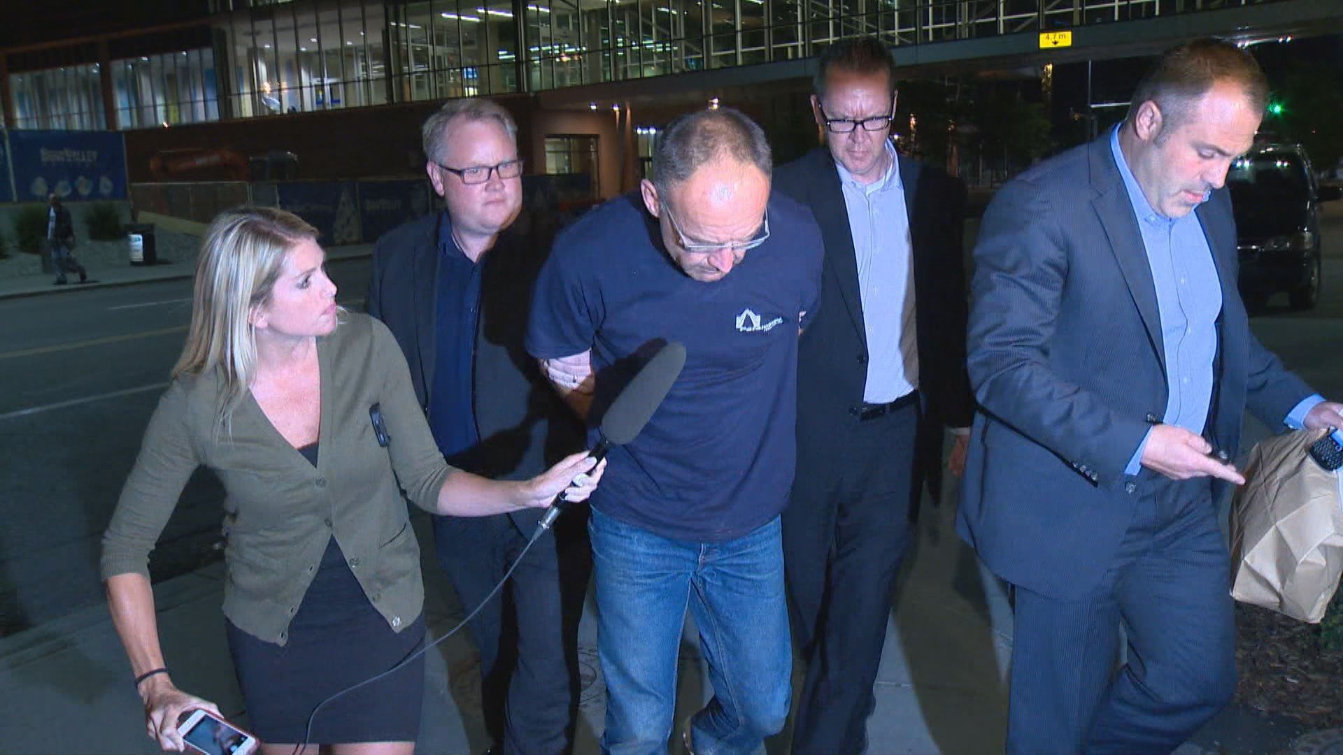 Douglas Garland is escorted into a Calgary police station in connection with the disappearance of Nathan O'Brien and his grandparents in Calgary, Alta.