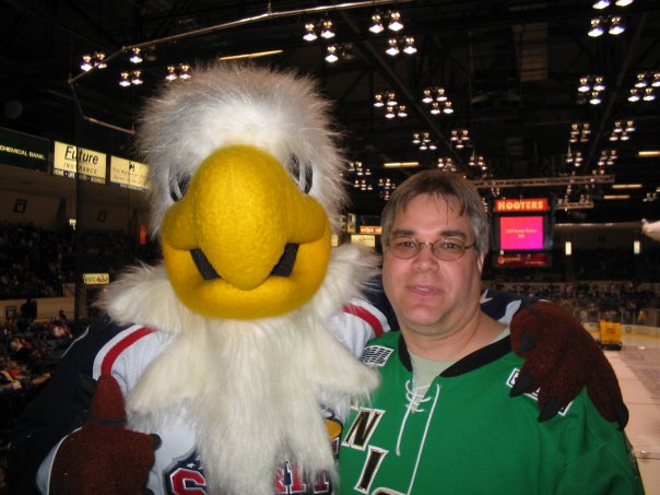 Longtime London Knights fan Rob Matic poses alongside Sammy Spirit during a game hosted by the Saginaw Spirit.