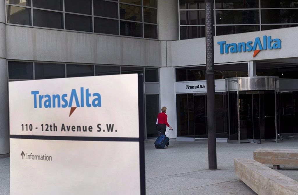 A woman walks towards the entrance of the TransAlta headquarters building in Calgary, on Tuesday, April 29, 2014. THE CANADIAN PRESS/Larry MacDougal.