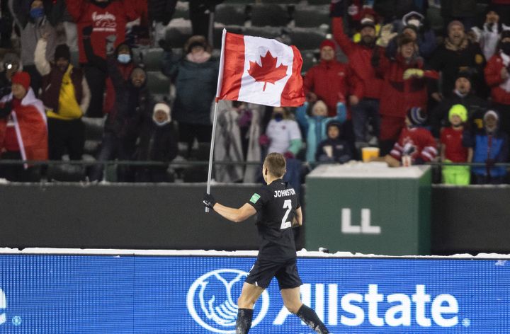 Canada’s Alistair Johnston (2) parades the flag to celebrate the win over Mexico during World Cup Qualifiers in Edmonton, Tuesday, Nov. 16, 2021.