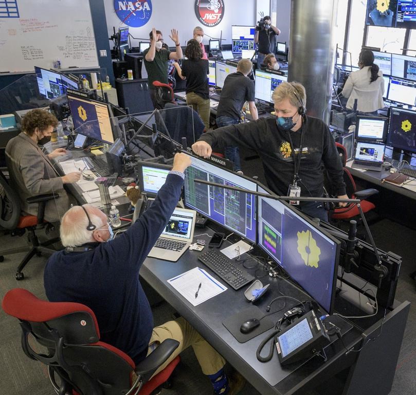 Engineering teams celebrate at the Space Telescope Science Institute in Baltimore as the second primary mirror wing of NASA's James Webb Space Telescope unfolds, before beginning the process of latching the mirror wing into place, Saturday, Jan. 8, 2022.