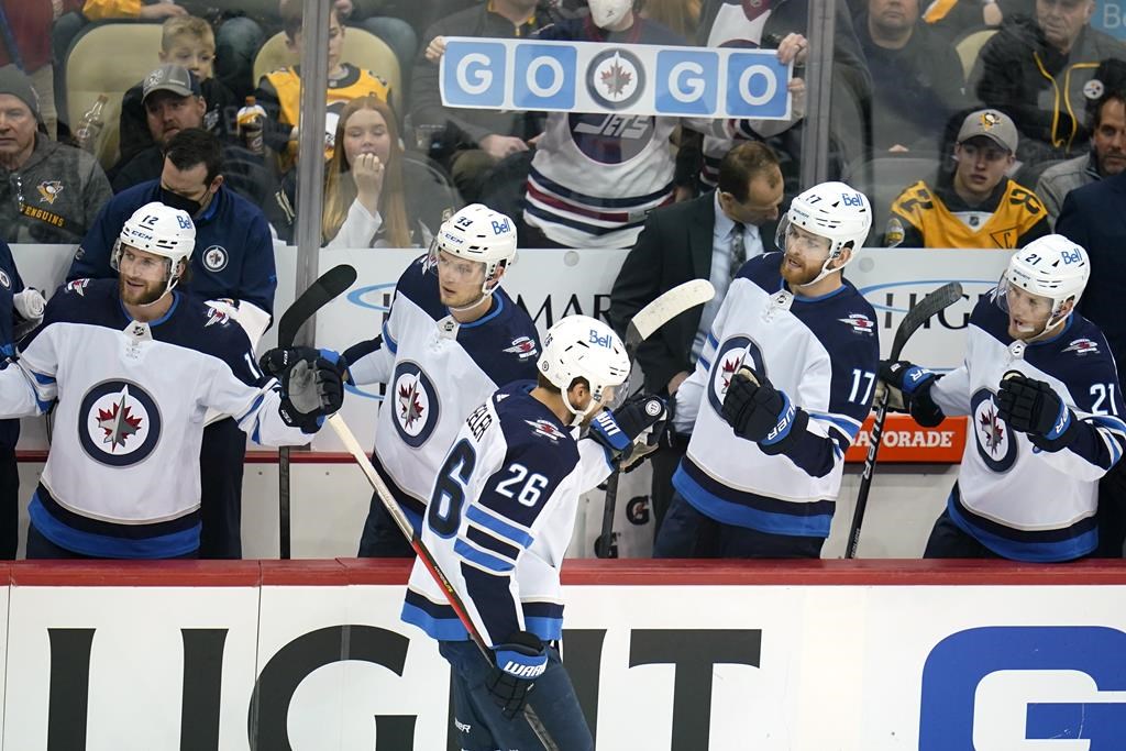Winnipeg Jets’ Blake Wheeler (26) returns to his bench after scoring during the first period of an NHL hockey game against the Pittsburgh Penguins in Pittsburgh, Sunday, Jan. 23, 2022.