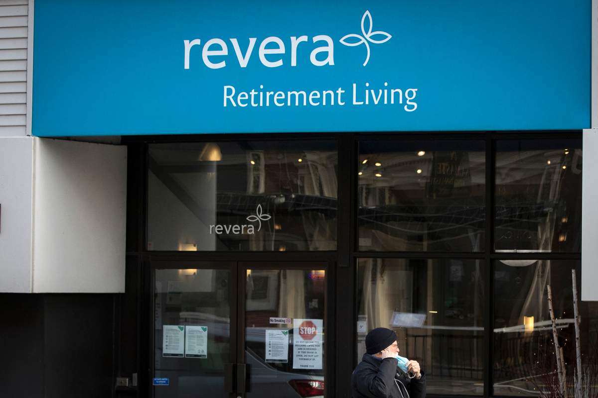 A person wears a mask while walking past Revera Retirement Living residence in Kingston, Ontario on Tuesday, December 8, 2020, as the COVID-19 pandemic continues across Canada and around the world. THE CANADIAN PRESS IMAGES/Lars Hagberg