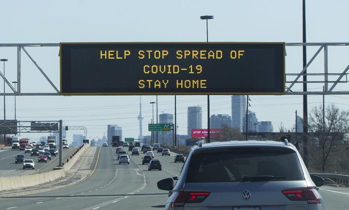 A screen with words of ”HELP STOP SPREAD OF COVID-19 STAY HOME” is seen in Toronto on April 8, 2021.