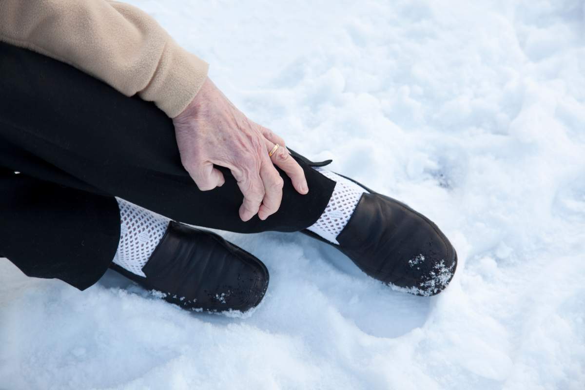 Women falls and holds ankle