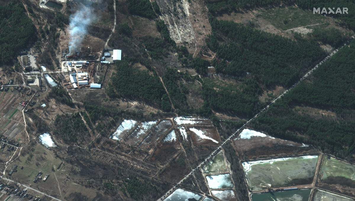 Burning homes and buildings are seen near a highway north of Ivankiv, Ukraine, where a Russian military convoy is heading toward Kyiv on Feb. 28, 2022.
