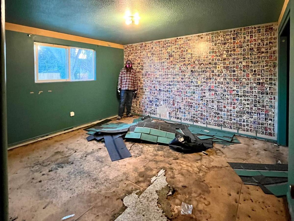 Luke Brodt stands next to the wall plastered in baseball cards.