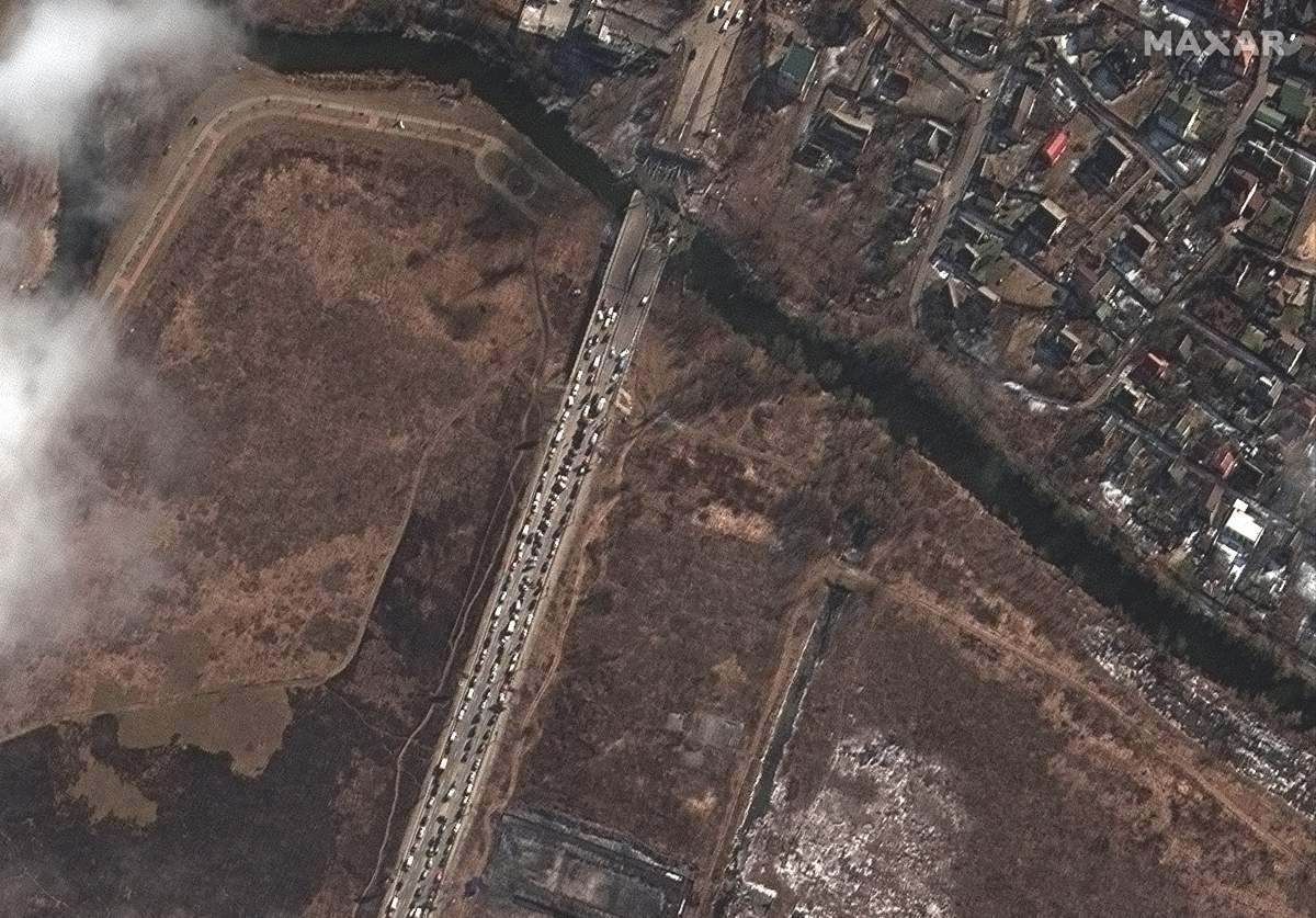 A long line of cars and people is seen trying to leave Irpin, Ukraine, near a damaged bridge on March 10, 2022.
