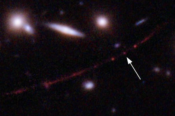 This image made available by NASA on Wednesday, March 30, 2022, shows the star Earendel, indicated by arrow, and the Sunrise Arc galaxy, stretching from lower left to upper right, optically bent due to a massive galaxy cluster between it and the Hubble Space Telescope which captured the light. 