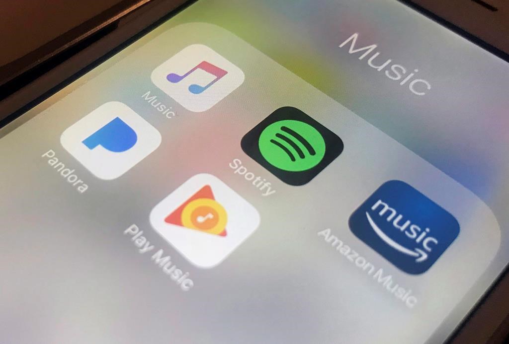 This Sunday, Jan. 28, 2018, photo shows music streaming apps clockwise from top left, Apple, Spotify, Amazon, Pandora and Google on an iPhone in New York. 