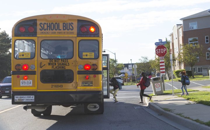 Students wearing face masks get on a school bus on Sept. 9, 2021. The chair of Hamilton's public school board says the latest indoor masking policy is not a "mandate" but a drive "encouraging" and "supporting" those opting in to get through a "respiratory illness crisis.".