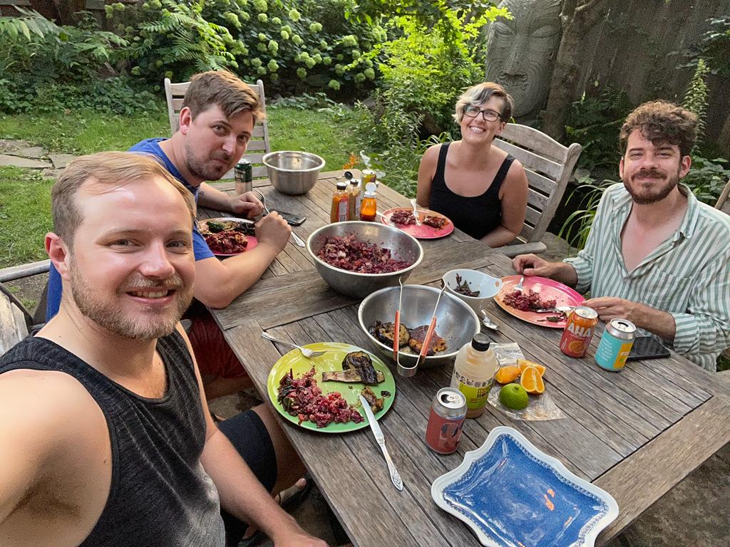 Co-owners of a Toronto home sit down together for a meal in their backyard