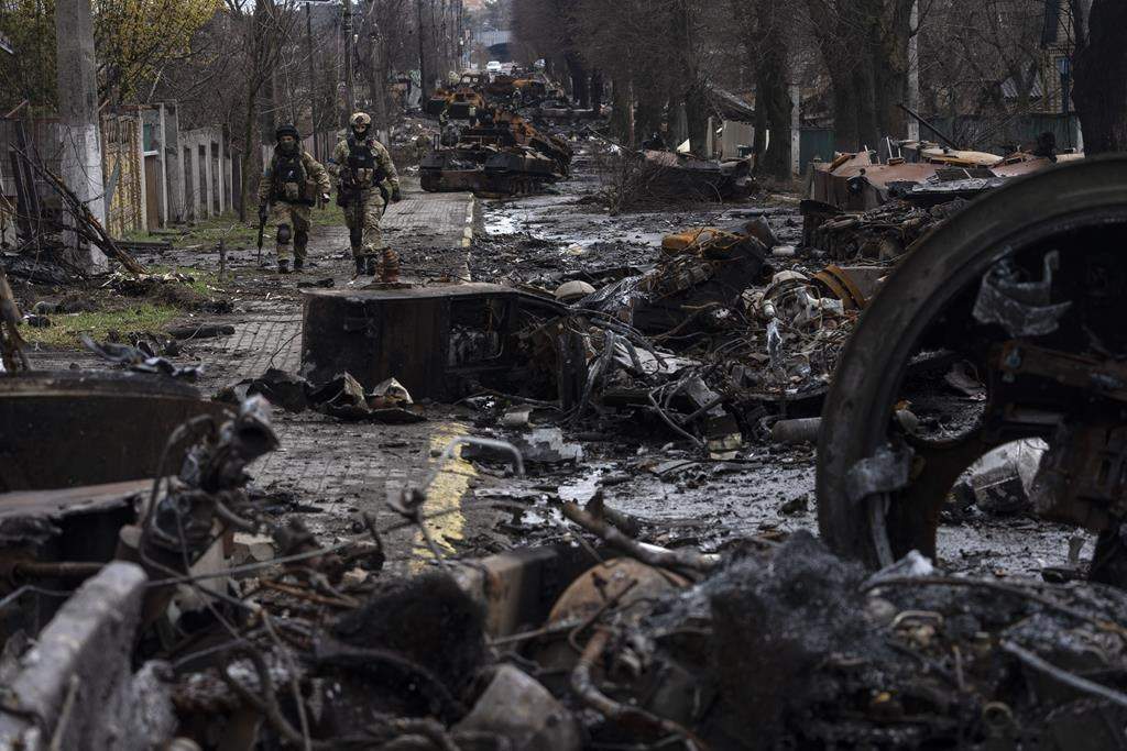 Soldiers walk amid destroyed Russian tanks in Bucha, on the outskirts of Kyiv, Ukraine on April 3. (AP Photo/Rodrigo Abd)
