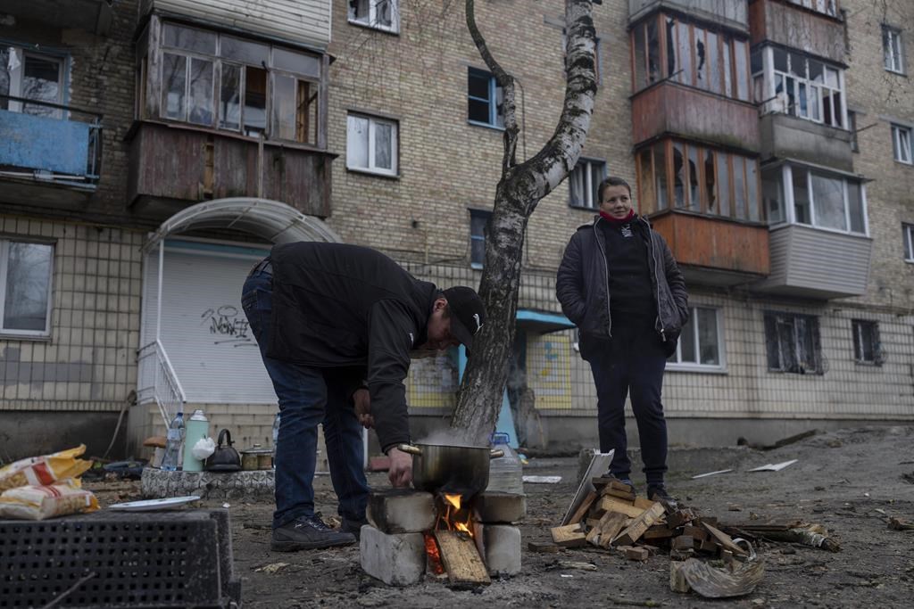 Oleksander Radkevich, 41, cooks on a makeshift fire next to his wife Irina Shekhovtsova outside their destroyed apartment building in the town of Borodyanka, Ukraine, on Saturday, April 9, 2022. Russian troops occupied the town of Borodyanka for weeks. Several apartment buildings were destroyed during fighting between the Russian troops and the Ukrainian forces in the town around 40 miles northwest of Kyiv